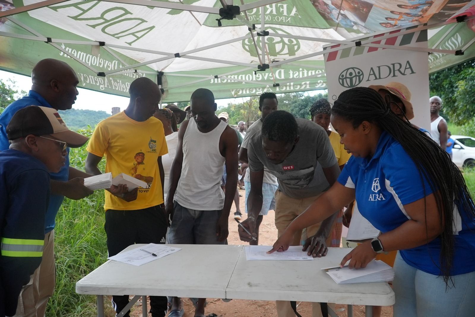 ADRA staff mentoring community members at an outdoor Young and Empowered outreach table